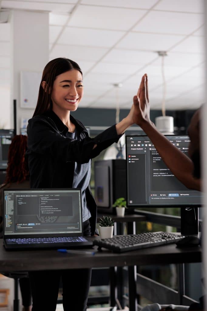 Diverse successful web developers celebrating code compiling