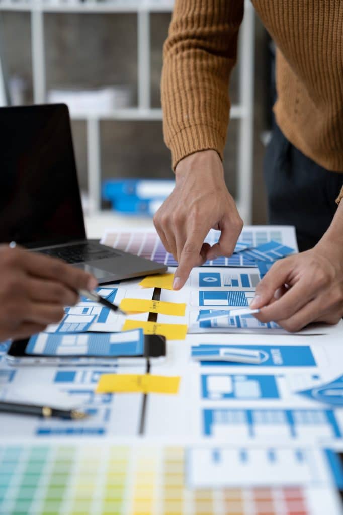 ux developers and ui designers, data researchers brainstorm on tabletop mobile app interface wirefr
