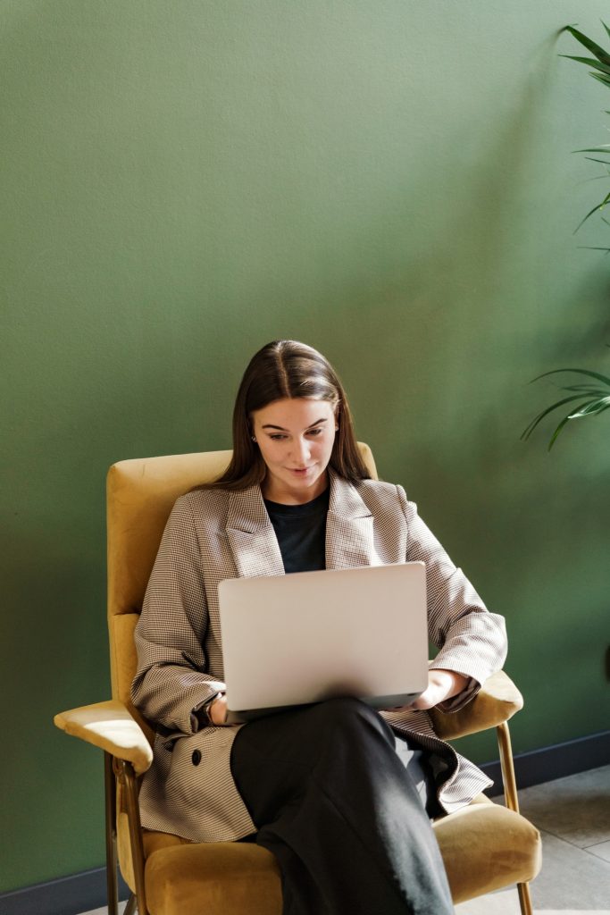 The SMM manager in the chair uses a laptop to pay for online goods in the website stores. The studen