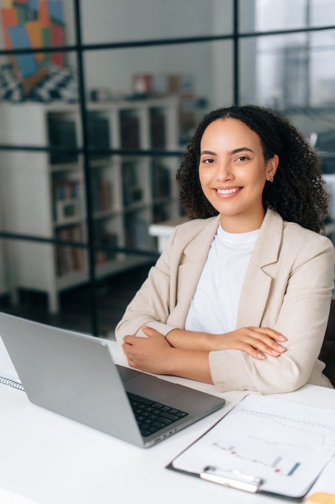 Vertical photo of a positive curly haired brazilian or hispanic business woman, company manager, ceo
